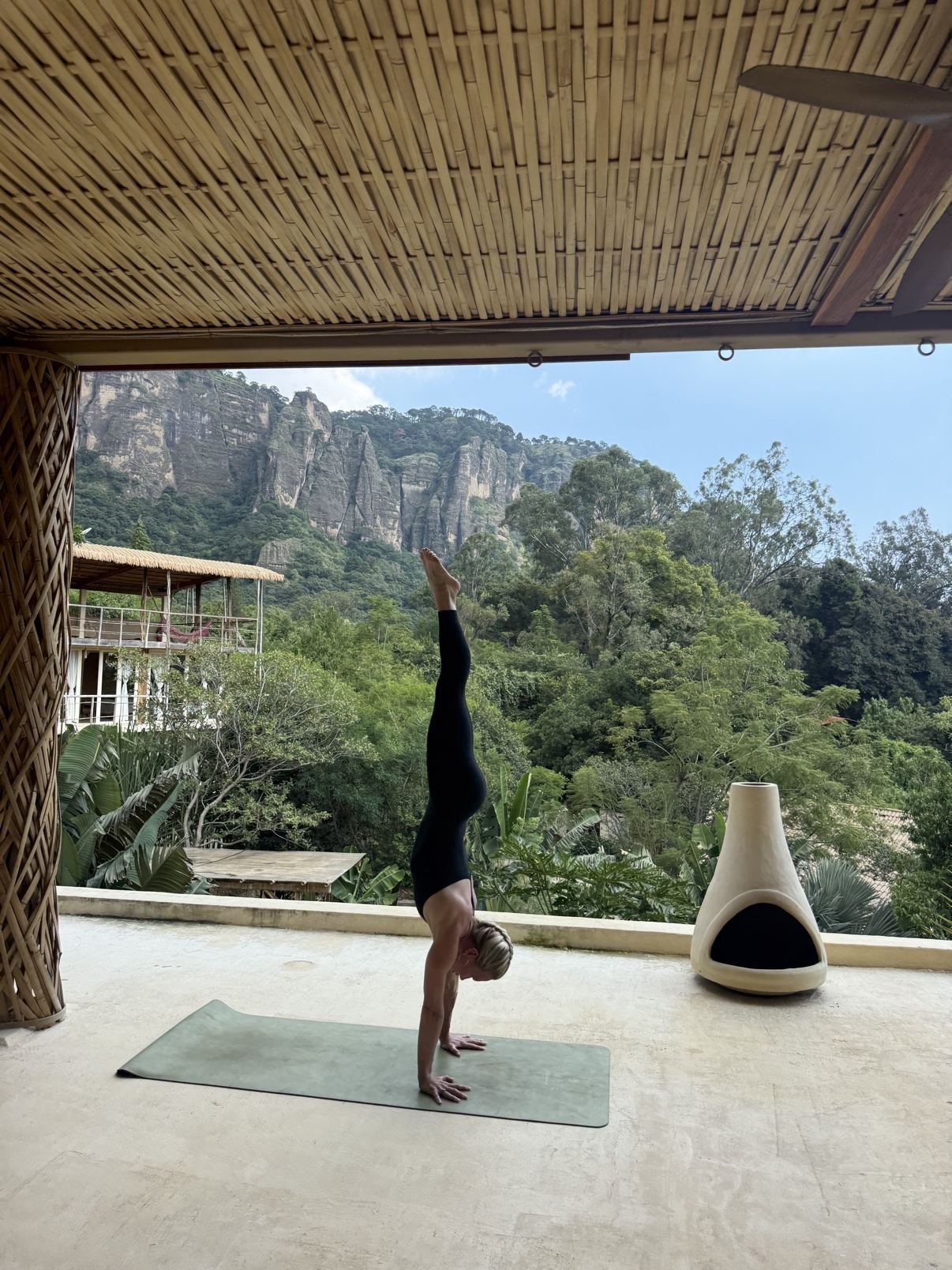 Sally practicing a handstand on a terrace overlooking the mountains